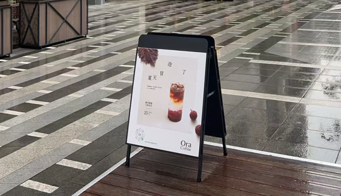 雨天办公楼外的 Ora 咖啡招牌