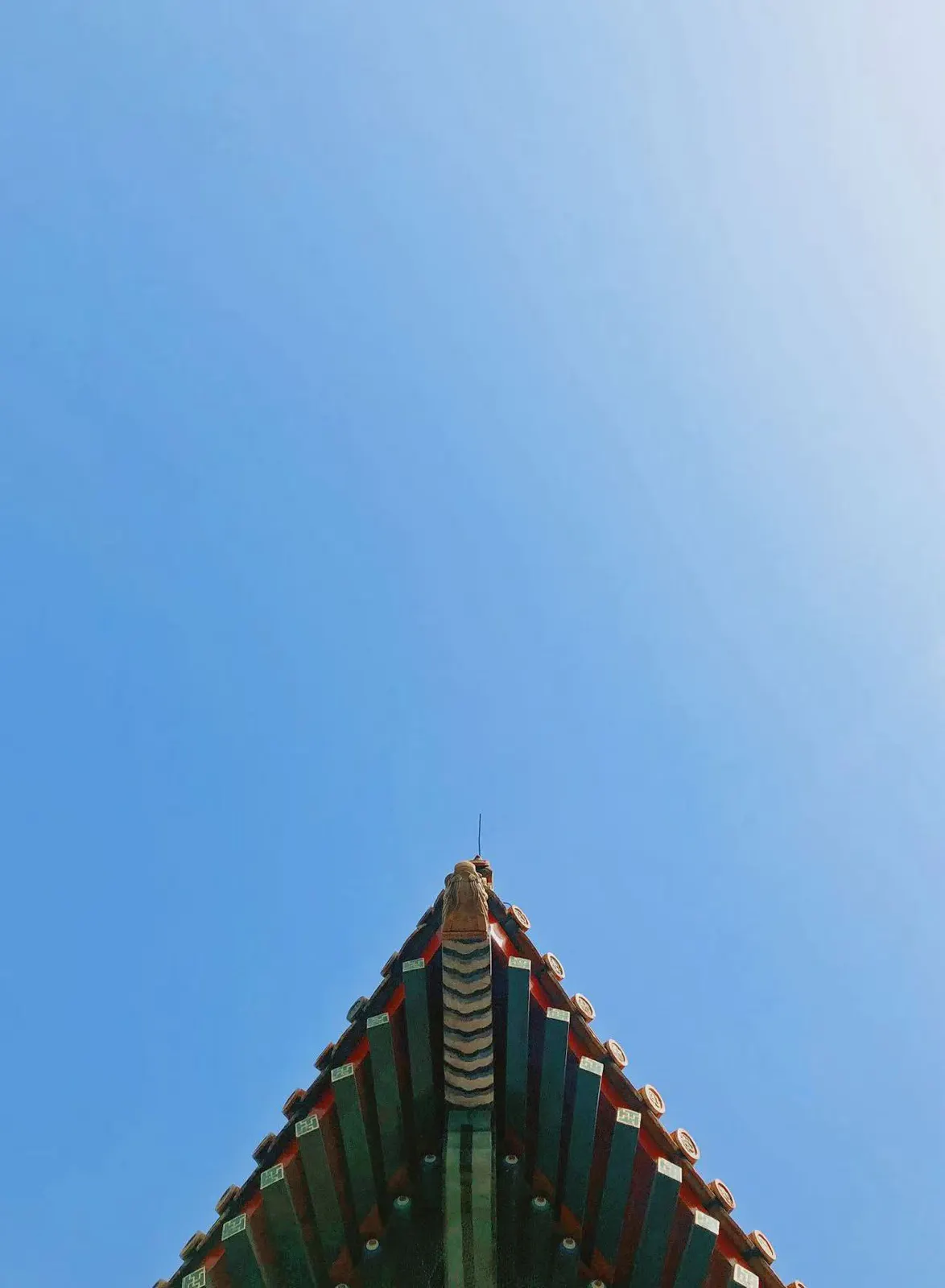 蓝天下建筑屋脊的对称尖角